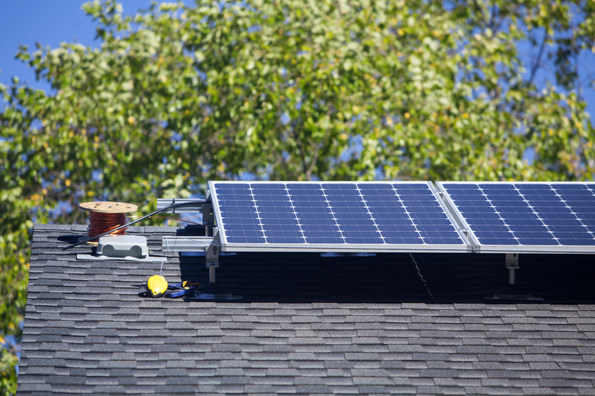 Installation of residential solar panels on the roof of a suburban home.